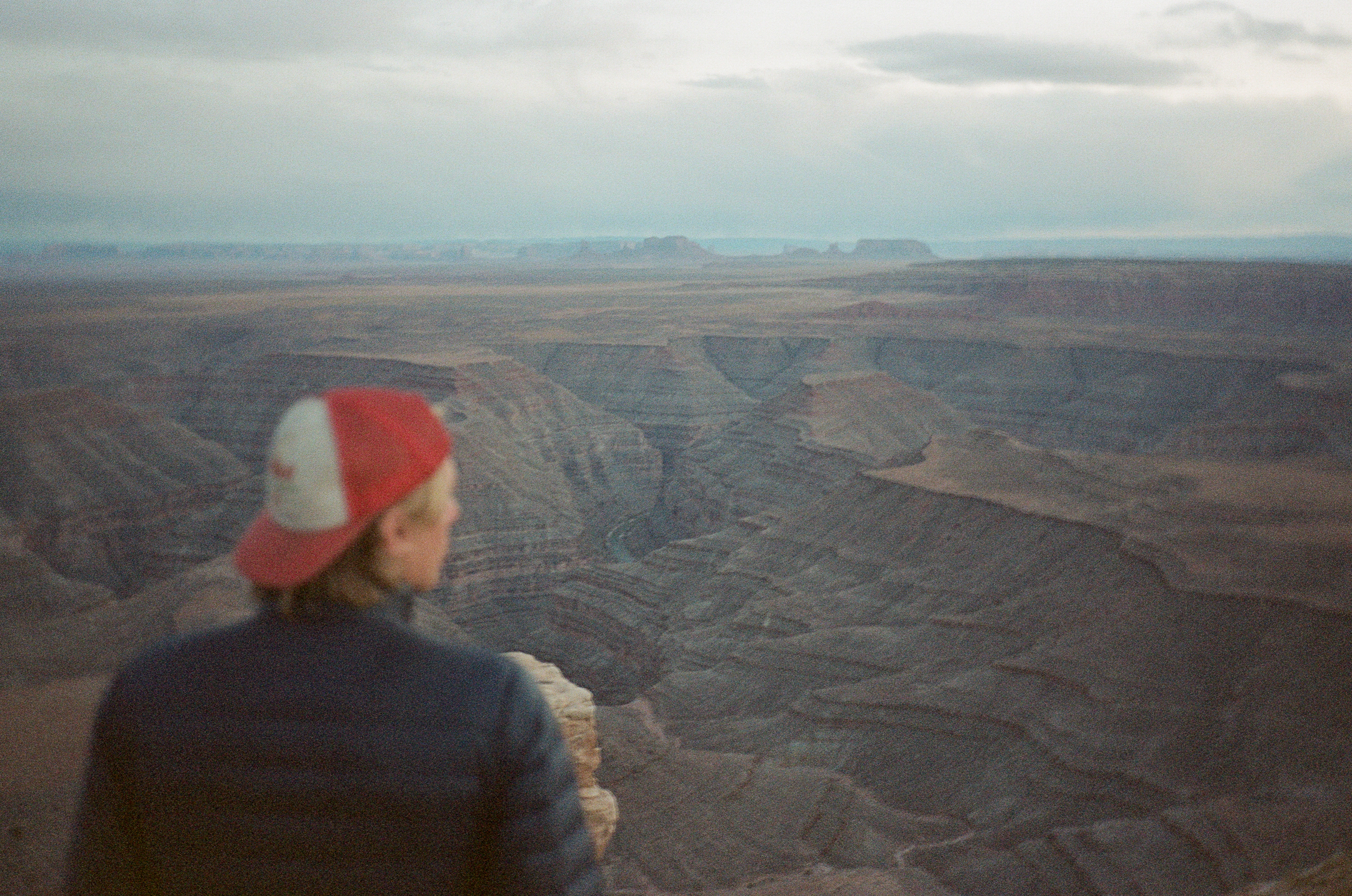 A figure looking out over a canyon at dusk
